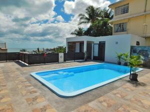 a swimming pool in front of a house at Coral Studio in La Gaulette