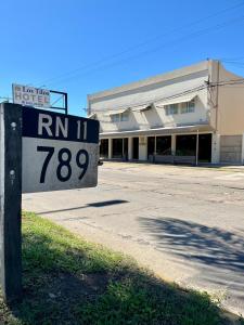 um sinal no lado de uma estrada em frente a um edifício em HOTEL LOS TILOS RECONQUISTA em Reconquista