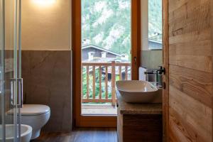 een badkamer met een wastafel en een toilet en een raam bij Méijon Salluard RTA in Courmayeur +72 foto's