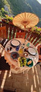 a table with plates of food and an umbrella at Arcera AGRITURISMO in Piana di Forcella