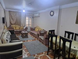 a living room with couches and chairs in a room at شقة مفروشة 5 سراير في كامب شيزار in Kafr ‘Ilwān
