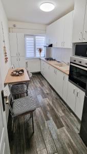 a kitchen with white cabinets and a wooden floor at Apartament Niki in Mangalia