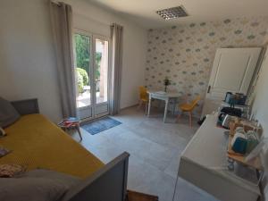 a living room with a bed and a table and a window at La Chambre du Saunei in Castelnau-de-Guers
