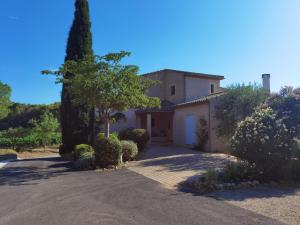 una casa blanca con un árbol y una entrada en La Chambre du Saunei, en Castelnau-de-Guers