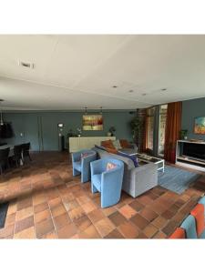 a living room with blue chairs and a couch at Domaine Heyen in Waimes