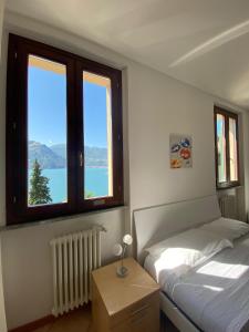 a bedroom with two beds and two windows at Regina Lake Como Condo in Dorio +91 photos