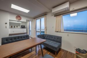 a dining room with a table and chairs and a window at Ocean Stay in Shiraoi