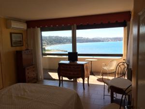 a bedroom with a large window with a view of the ocean at Villa La Lézardière in Bandol