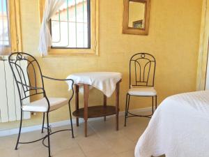 um quarto com duas cadeiras, uma mesa e uma cama em Villa La Lézardière em Bandol