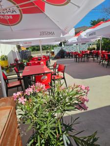 a patio with tables and chairs and pink flowers at Vila Angelys in Tuzla