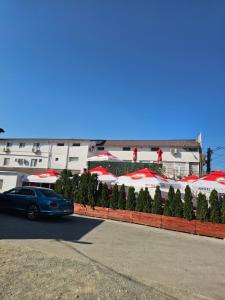 a car parked in front of a building with umbrellas at Vila Angelys in Tuzla