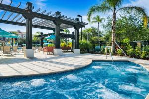 ein Swimmingpool mit Pergola und Schaukel in der Unterkunft Orlando Resort Rentals at Universal Boulevard in Orlando