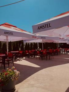 a group of tables and chairs under umbrellas at Vila Angelys in Tuzla