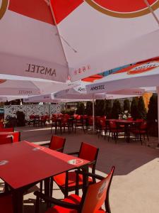 a group of tables and chairs under an umbrella at Vila Angelys in Tuzla