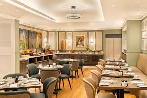 a restaurant with tables and chairs and a kitchen at Brooks Hotel in Dublin