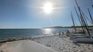 a group of people standing on a beach with boats at Les amis de Saint Jacques in Sarzeau
