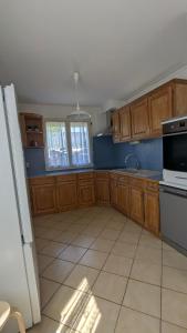 a kitchen with wooden cabinets and a white appliance at Les amis de Saint Jacques in Sarzeau +7 photos