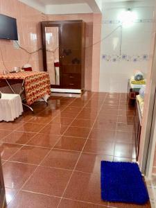 a bathroom with a table and a shower with a blue rug at Nhà Nghỉ Quỳnh Hương - Quynh Huong Hostel in Long Thành
