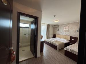 a hotel room with two beds and a shower at Hotel Mondial - Eforie Nord in Eforie Nord +26 photos