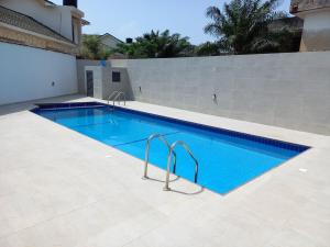a swimming pool with blue water in a yard at Modern 1-Bedroom Apartment in Cantonments in Accra