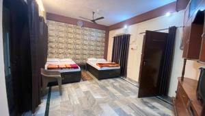 a room with two beds and a chair in it at kashidham home stays in Varanasi +13 photos