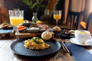 a table with a plate of food and glasses of orange juice at Kraina Jezior in Ostróda