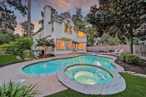 a home with a swimming pool in the yard at The Woodlands Gem with Pool and Spa in The Woodlands