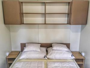 a bed with two pillows on it in a room at Badacsony Camping in Badacsonytomaj