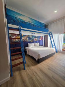 a bedroom with a blue bunk bed with a ladder at Marine Bay Sanur in Sanur
