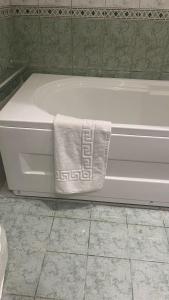 a bath tub with a towel on the side of it at شاليه La veranda in Durat  Alarous