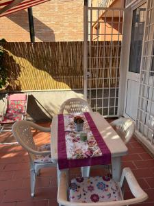 a table and chairs on a patio with a quilt at La Casetta di Francesca,Anguillara Sabazia in Anguillara Sabazia