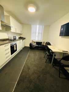 eine Küche mit einem Tisch und Stühlen sowie eine Küche mit einem Sofa in der Unterkunft Private Minimalist 2 Bedroom Apartment with Netflix in Ilkeston
