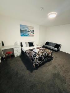 ein Schlafzimmer mit einem Bett und einem Schreibtisch darin in der Unterkunft Private Minimalist 2 Bedroom Apartment with Netflix in Ilkeston