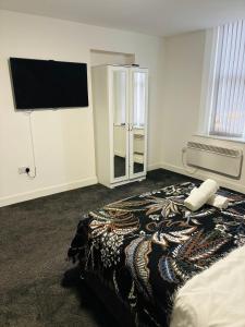 ein Schlafzimmer mit einem Bett und einem Flachbildfernseher in der Unterkunft Private Minimalist 2 Bedroom Apartment with Netflix in Ilkeston
