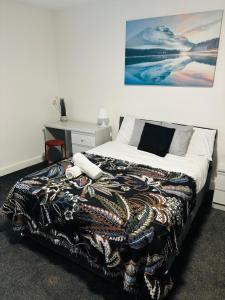 ein Schlafzimmer mit einem Bett und einem Schreibtisch mit einem Bild an der Wand in der Unterkunft Private Minimalist 2 Bedroom Apartment with Netflix in Ilkeston + 9 Fotos