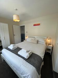 a bedroom with a large white bed with towels on it at The Harrogate Penthouse in Harrogate