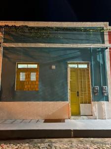 a building with two windows and a yellow door at Casa Zuilas in São Luís