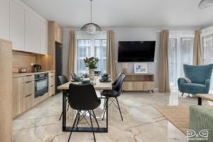 Una cocina y un comedor con mesa y sillas. en Apartament Pelikan D&D Apartments, en Międzywodzie 43 fotos más