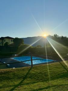 a view of a pool with the sun setting at Casa Lagobello, Piscina e Relax sul Lago Maggiore in Germignaga