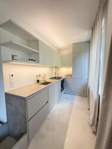 a kitchen with white cabinets and a large window at Central & Modern Apartment in Banská Bystrica
