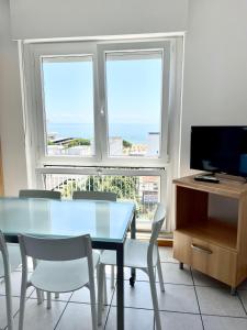 a dining room with a table and chairs and a television at Condominio Cam 78 in Lignano Sabbiadoro