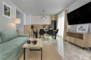 una sala de estar con un sofá y una mesa en Apartament Pelikan D&D Apartments, en Międzywodzie