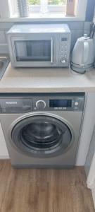 a microwave sitting on top of a washing machine at spacious self-contained accommodation 135 cantebury road Herne bay CT6 5RZ in Kent
