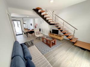 a living room with a blue couch and a staircase at Casa Norbina in Ribeira Quente