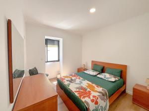 a bedroom with a bed and a dresser in it at Casa Norbina in Ribeira Quente