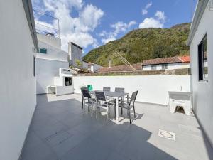 a patio with a table and chairs on a building at Casa Norbina in Ribeira Quente