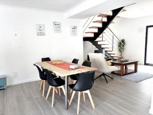 a dining room with a table and chairs and a staircase at Casa Norbina in Ribeira Quente
