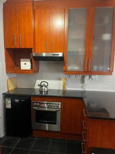 a kitchen with wooden cabinets and a stove at Live Like a Local in Stellies - By ARPA Hospitalities in Stellenbosch