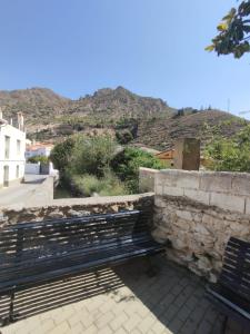 NigüelasにあるCasa Erasの石垣の横に座るベンチ