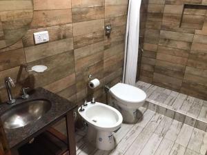 a bathroom with a toilet and a sink at Catamarca 4855 fondo derecha in La Lucila del Mar +12 photos